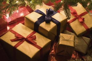 Christmas presents piled underneath a christmas tree. Dar y recibir regalos